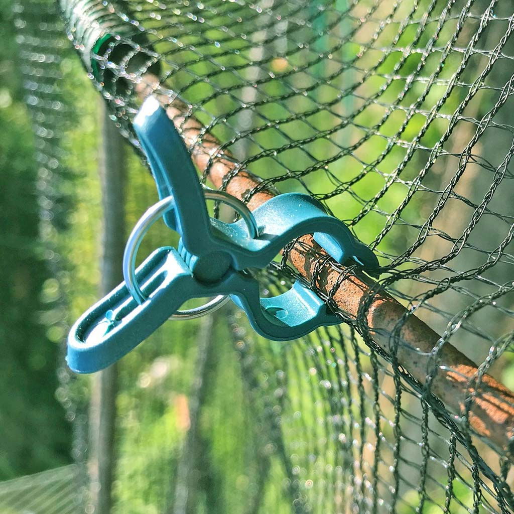 Blå plastklemme der holder et havennet på plads