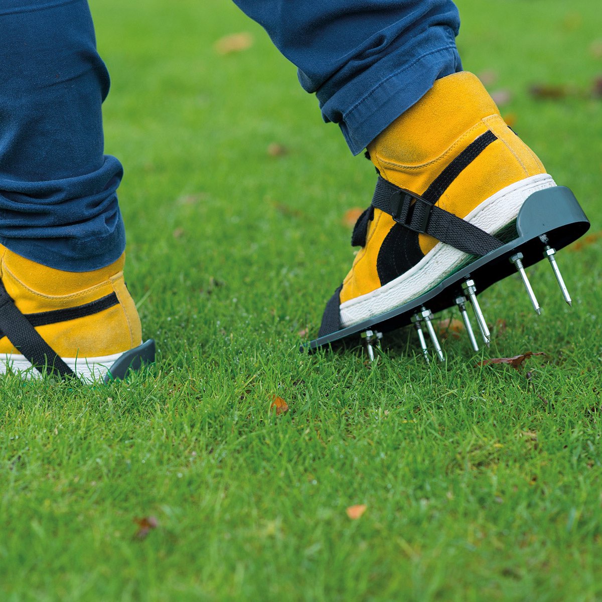 Person med luftersko med pigge på græsplæne