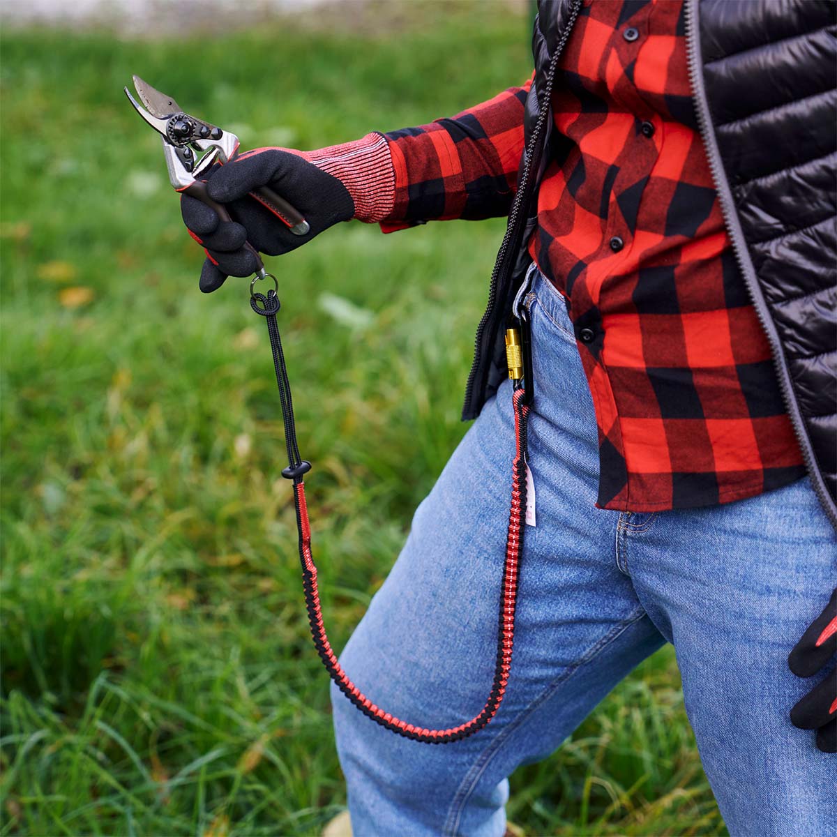 Person bruger havesaks med elastisk sikkerhedsstrop