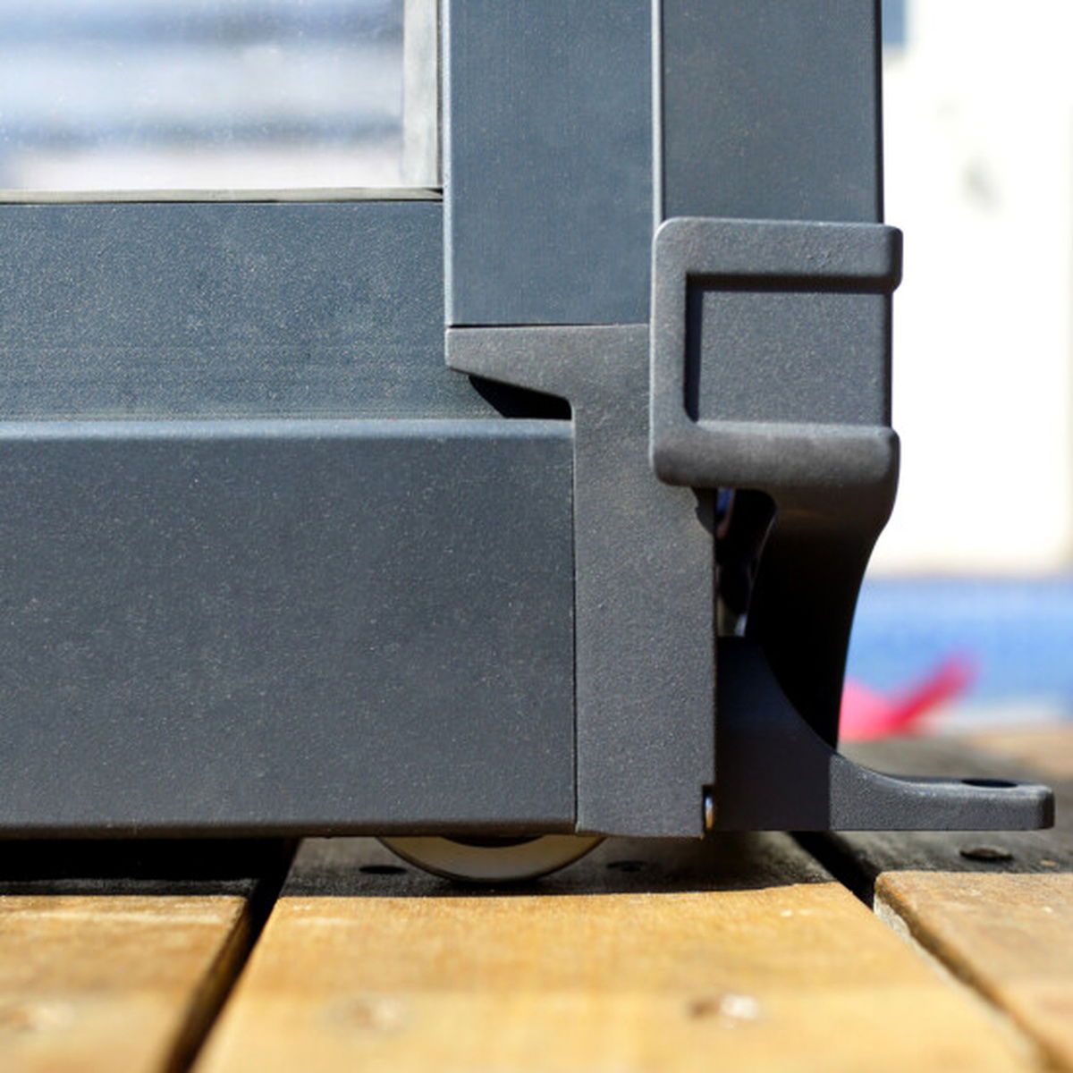 Grå aluminiums-skyde­dør med hjul på trægulv