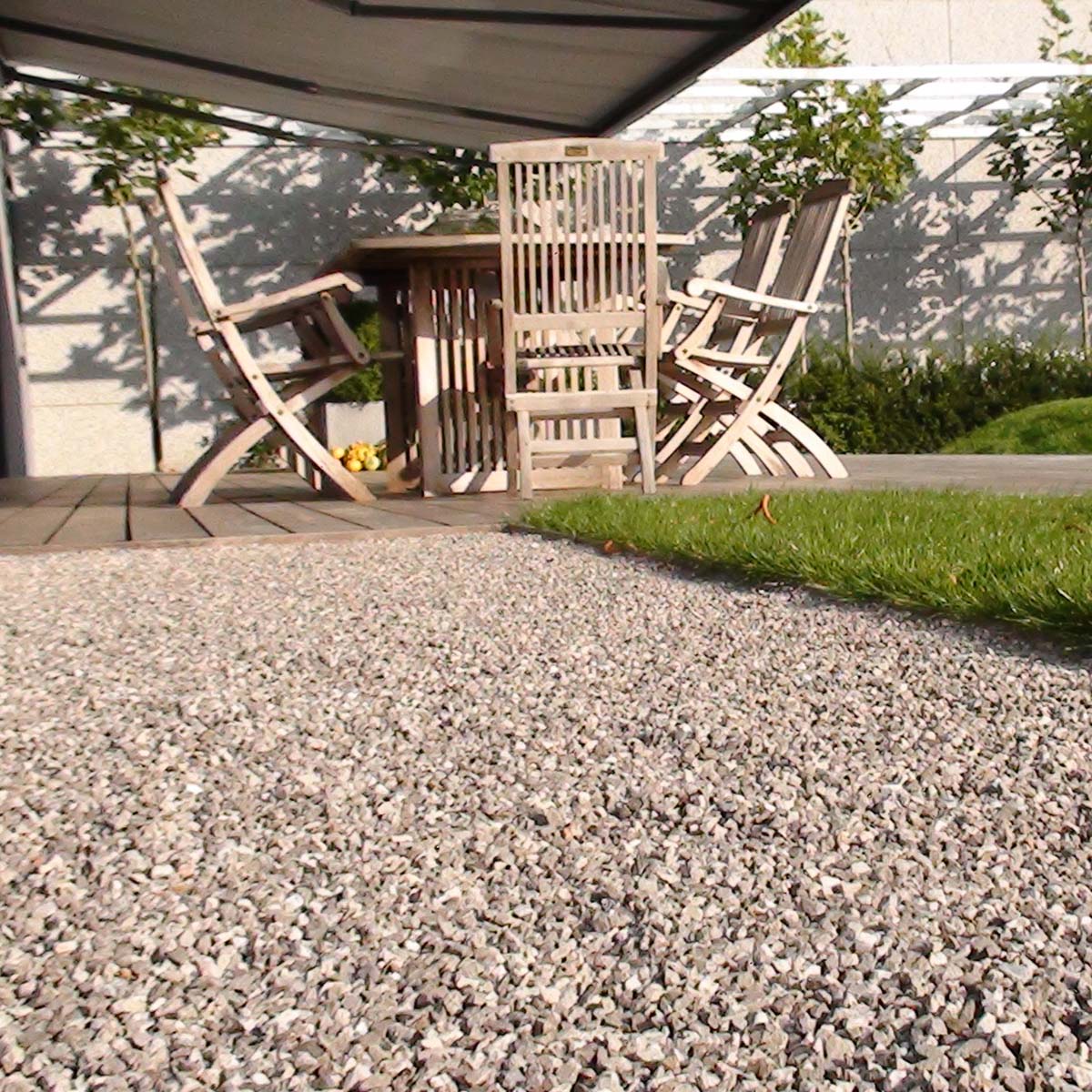 Dekorativt grus ved terrasse med havemøbler i træ