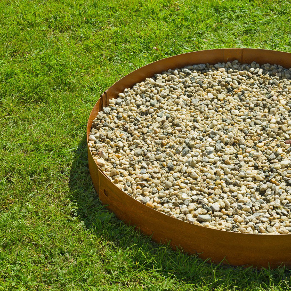 Rund cortenstål bedafgrænser fyldt med dekorationsgrus