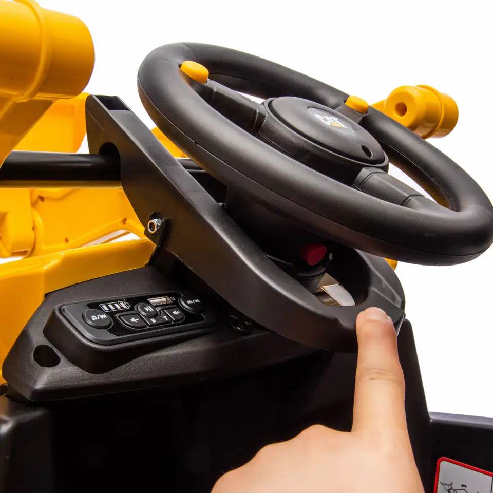 Nærbillede af rat og kontrolpanel på CAT® el-rendegraver fra Nordic Play, 2 x 10,8V motor, MP3-afspiller og kontrolknapper til lyd og fjernbetjening