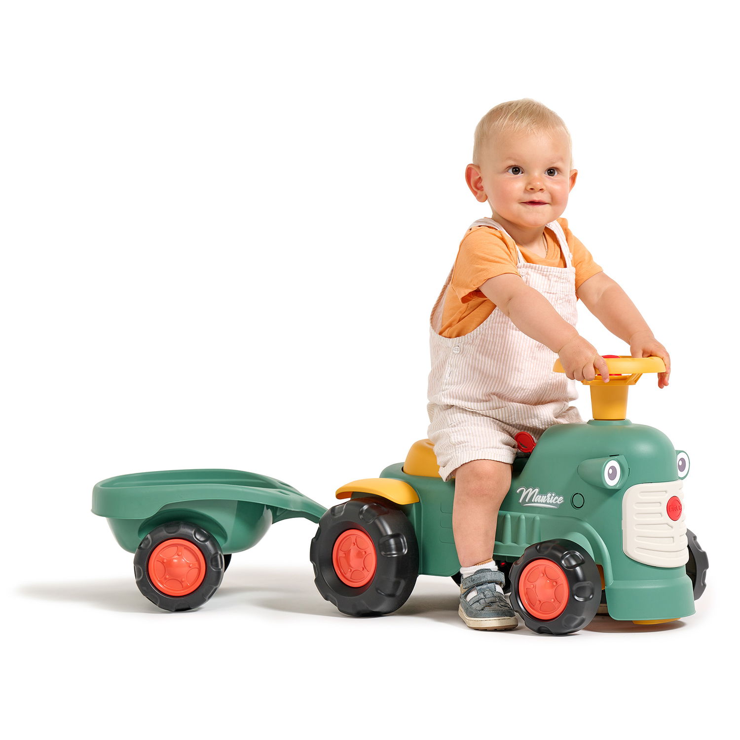 Barn kører på grøn legetraktor med trailer