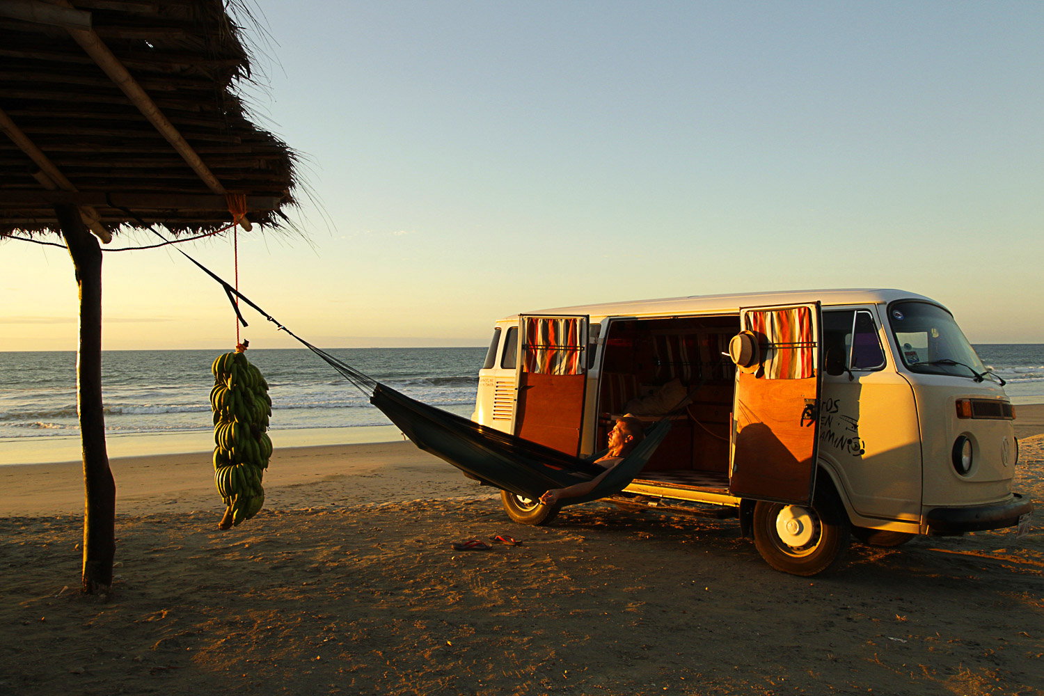 Hængekøje ved campingbus på stranden i solnedgang
