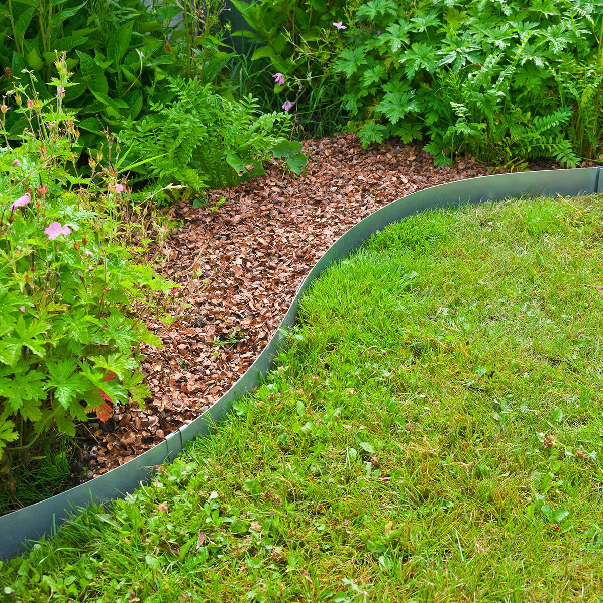 Metal bedkant mellem græsplæne og blomsterbed