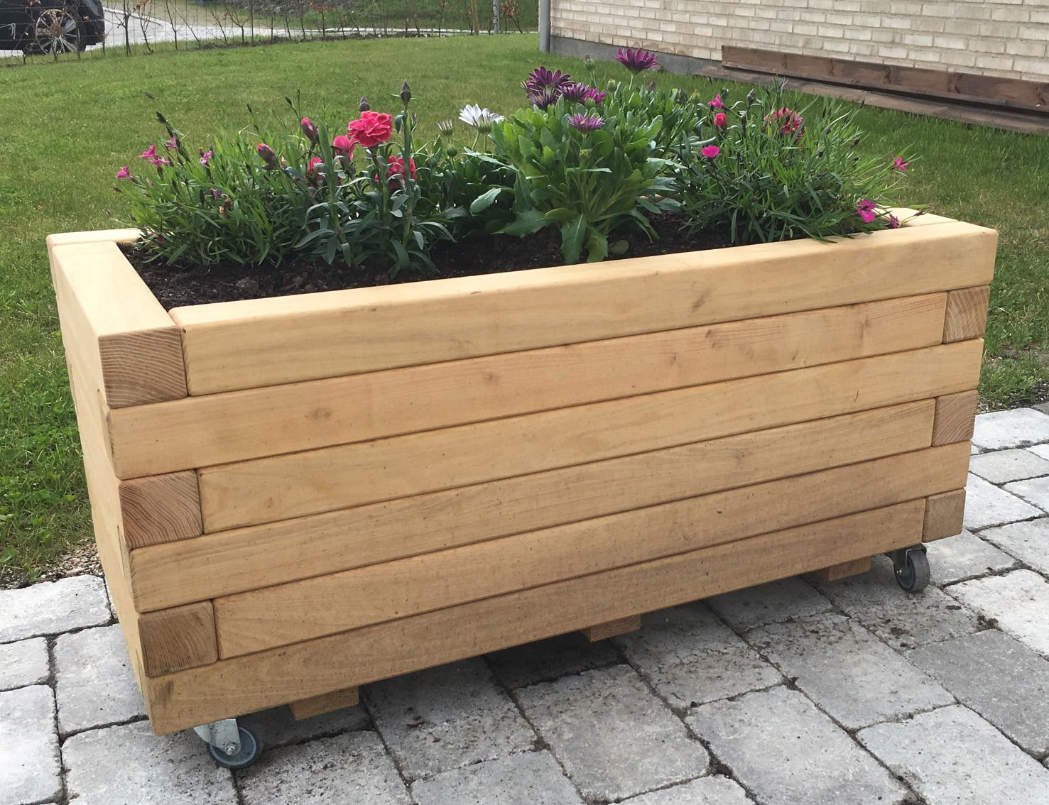 Flytbar rektangulær højbede i lyst træ med blomster