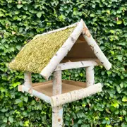 Fuglefoderhus i birketræ på stander med stråtag – HORTUS, 146 cm Fuglefoderhus i ægte birketræ på stander med jordspyd og beskyttende stråtag, rummelig foderplatform til haven, beskytter mod regn og sne – HORTUS
