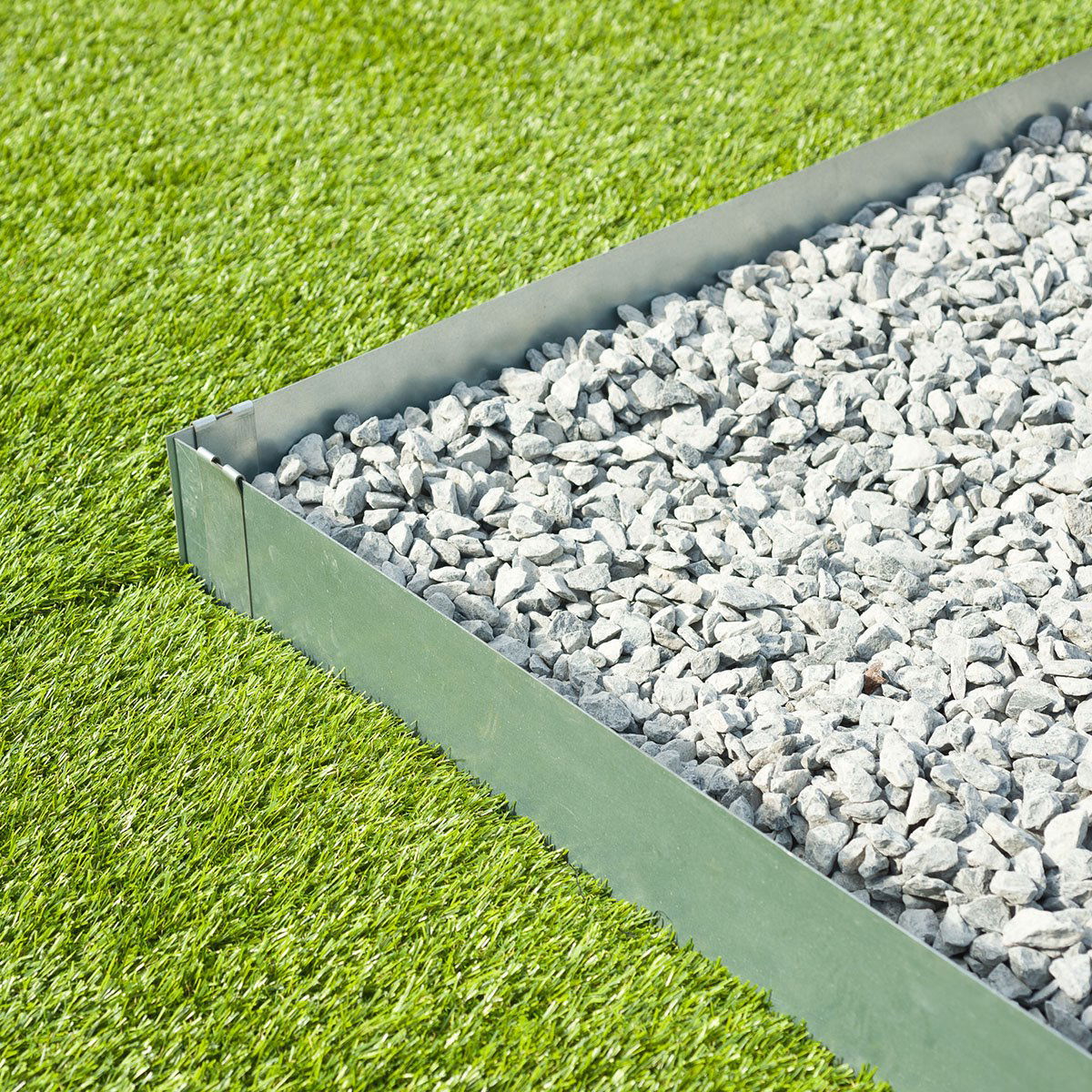 Metalkant som afgrænsning mellem grusbed og græsplæne