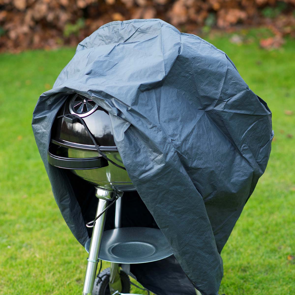 Sort grillovertræk på kuglegrill i haven