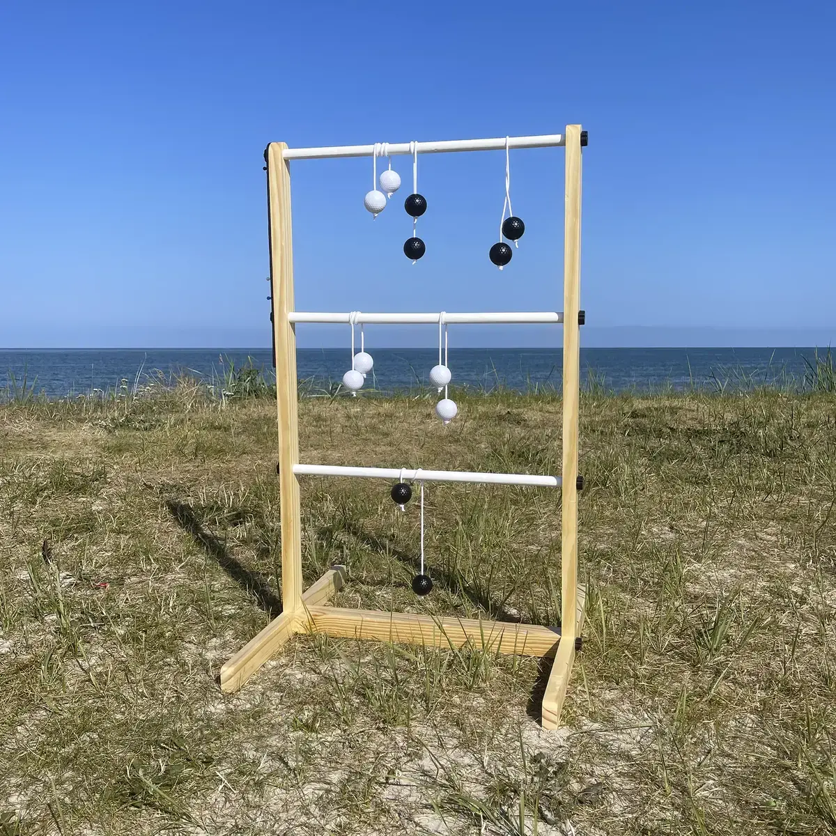 Laddergolf havespil i træ med kugler ved stranden
