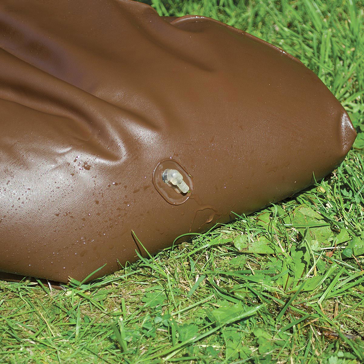 Brun oppustelig vandpose med ventil på græs
