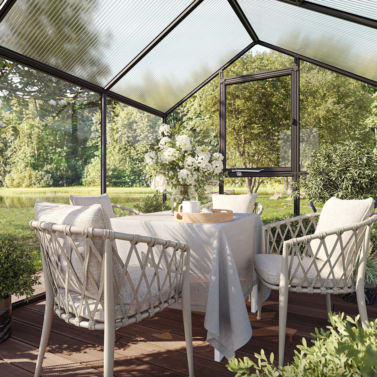 Lyst drivhus med spisebord og fletstole i haven