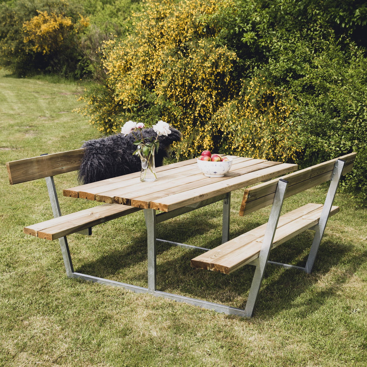 Havebord i træ med faste bænke på græsplæne