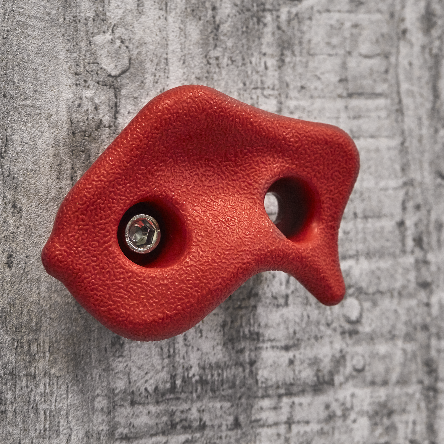 Rødt klatregreb monteret på grå klatrevæg