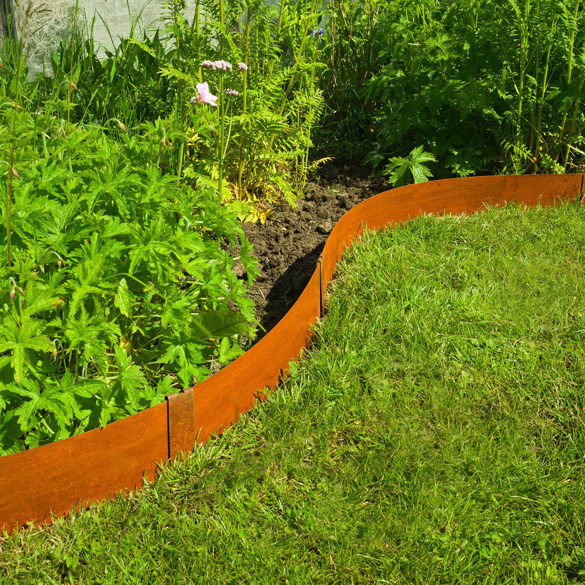 Bølget cortenstål plænekant mellem græs og bed