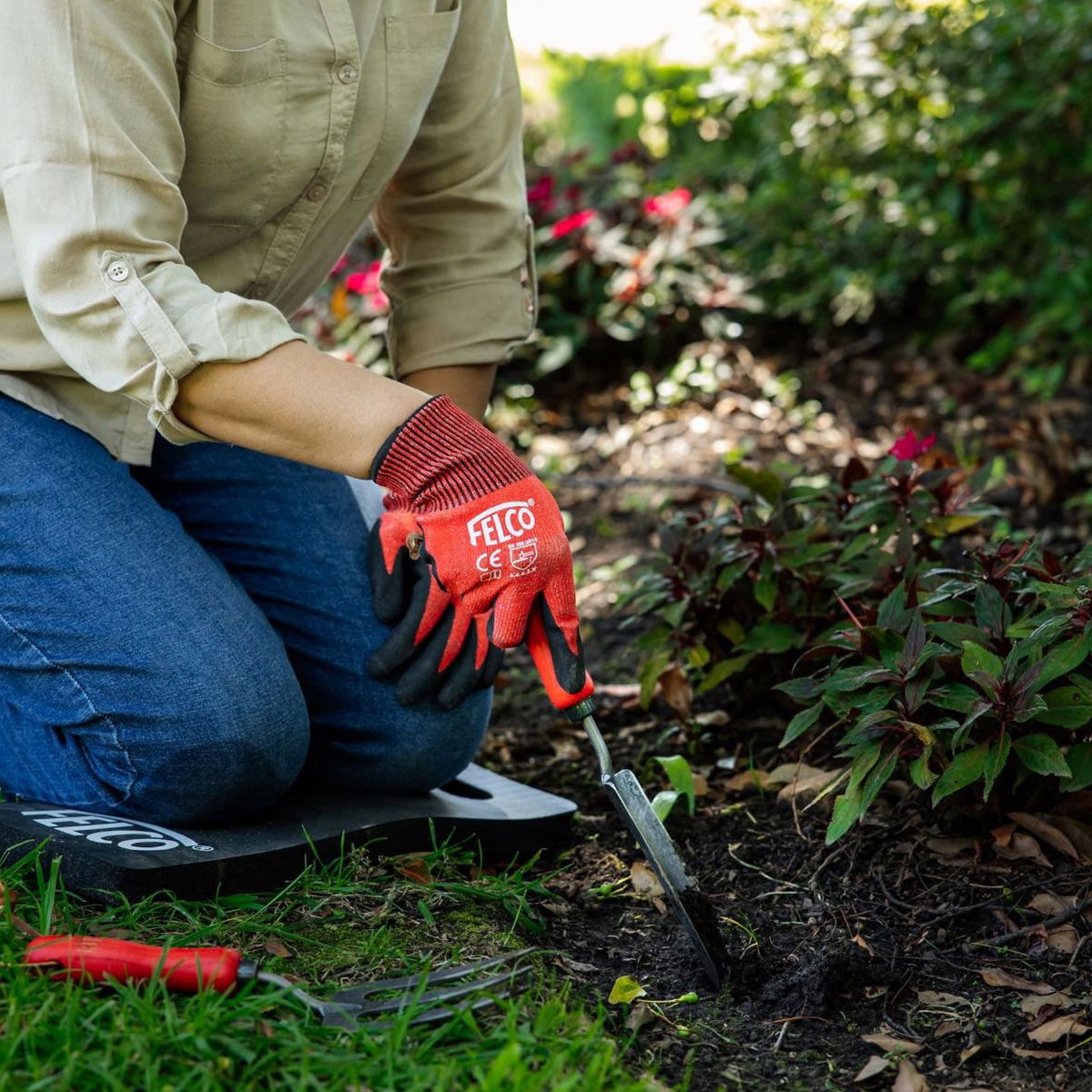 Person luge i bed med røde FELCO havehandsker