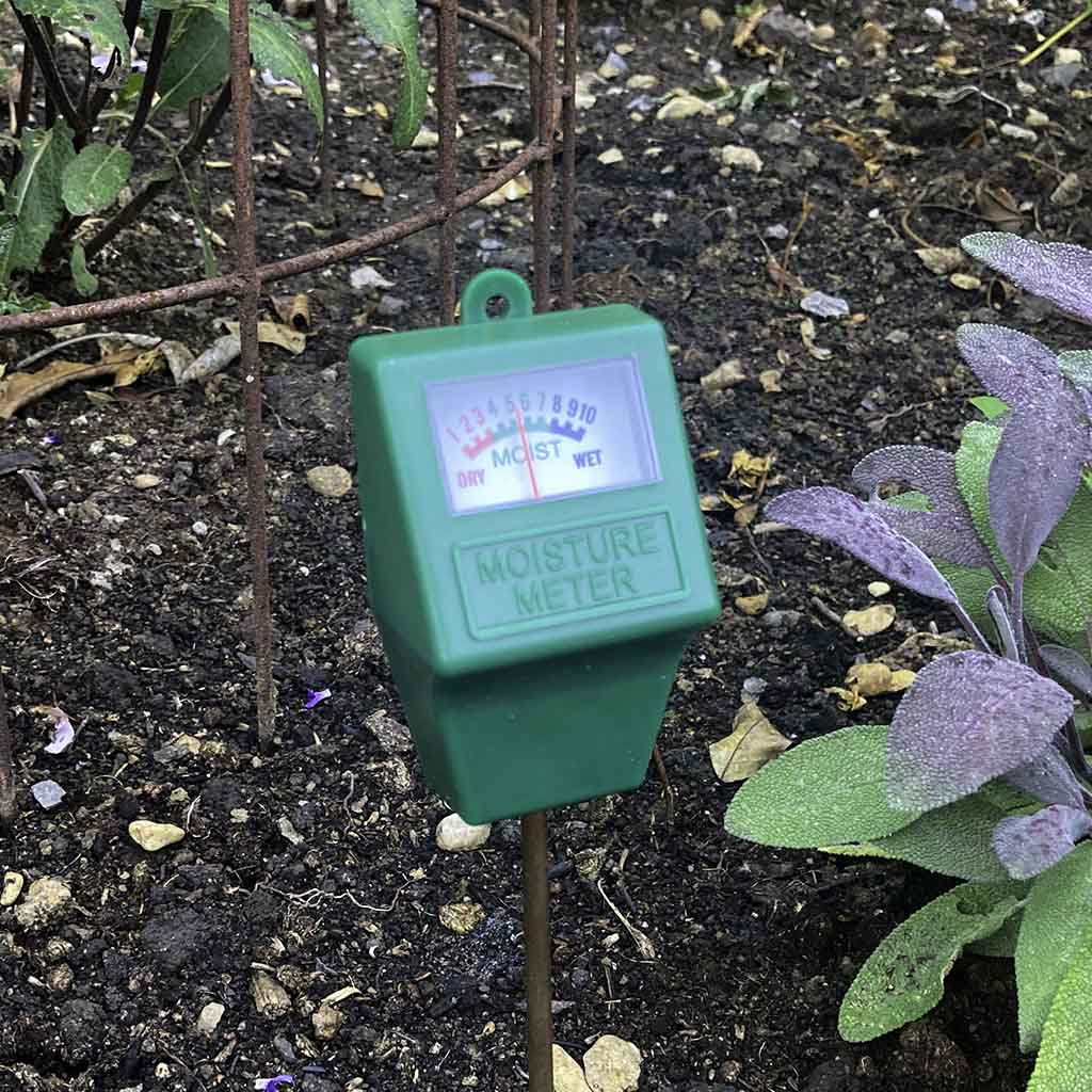 Grøn jordfugtighedsmåler i blomsterbed