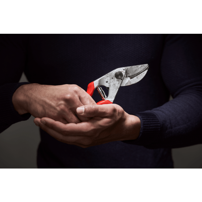 Mand holder robust pladesaks med rødt greb