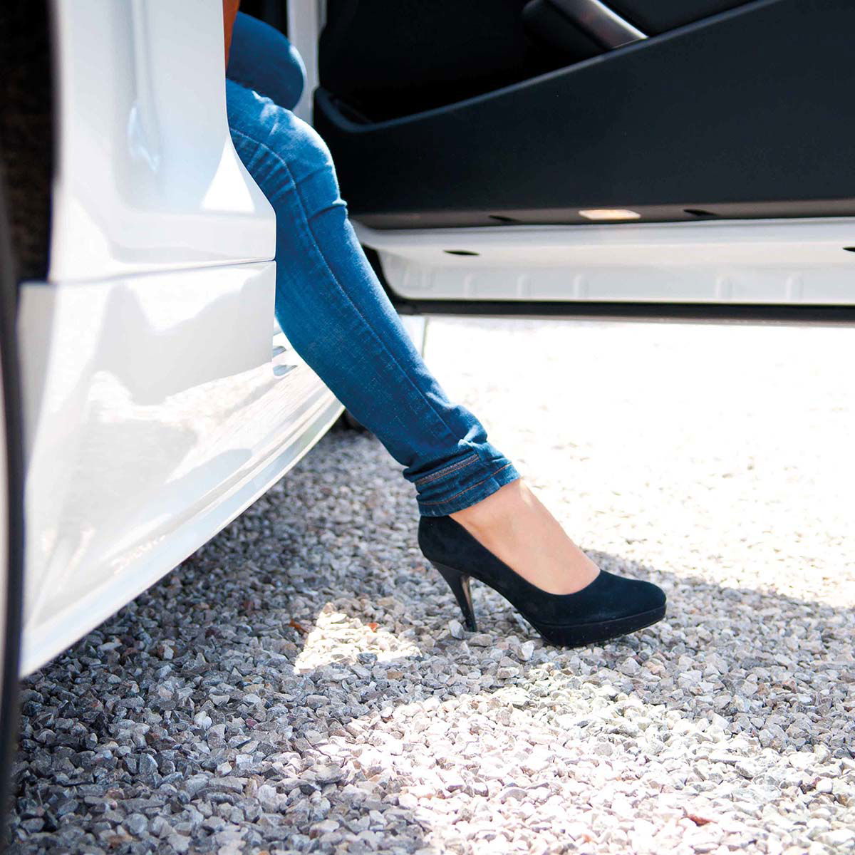 Kvinde i jeans stiger ud af bil i sorte pumps