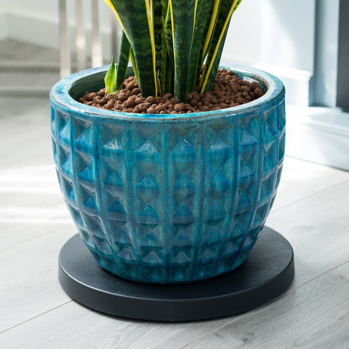 Blå keramisk plantekrukke med mønster på gulv