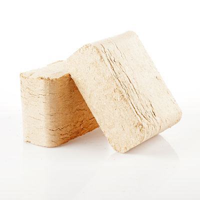 Lyse træbriketter stablet på hvid baggrund