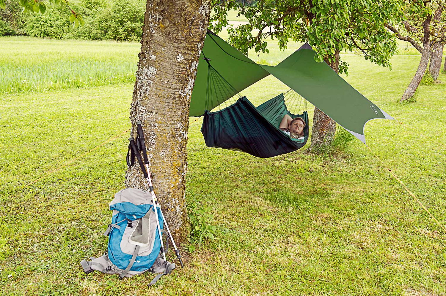 Mand slapper af i hængekøje med tarp i naturen