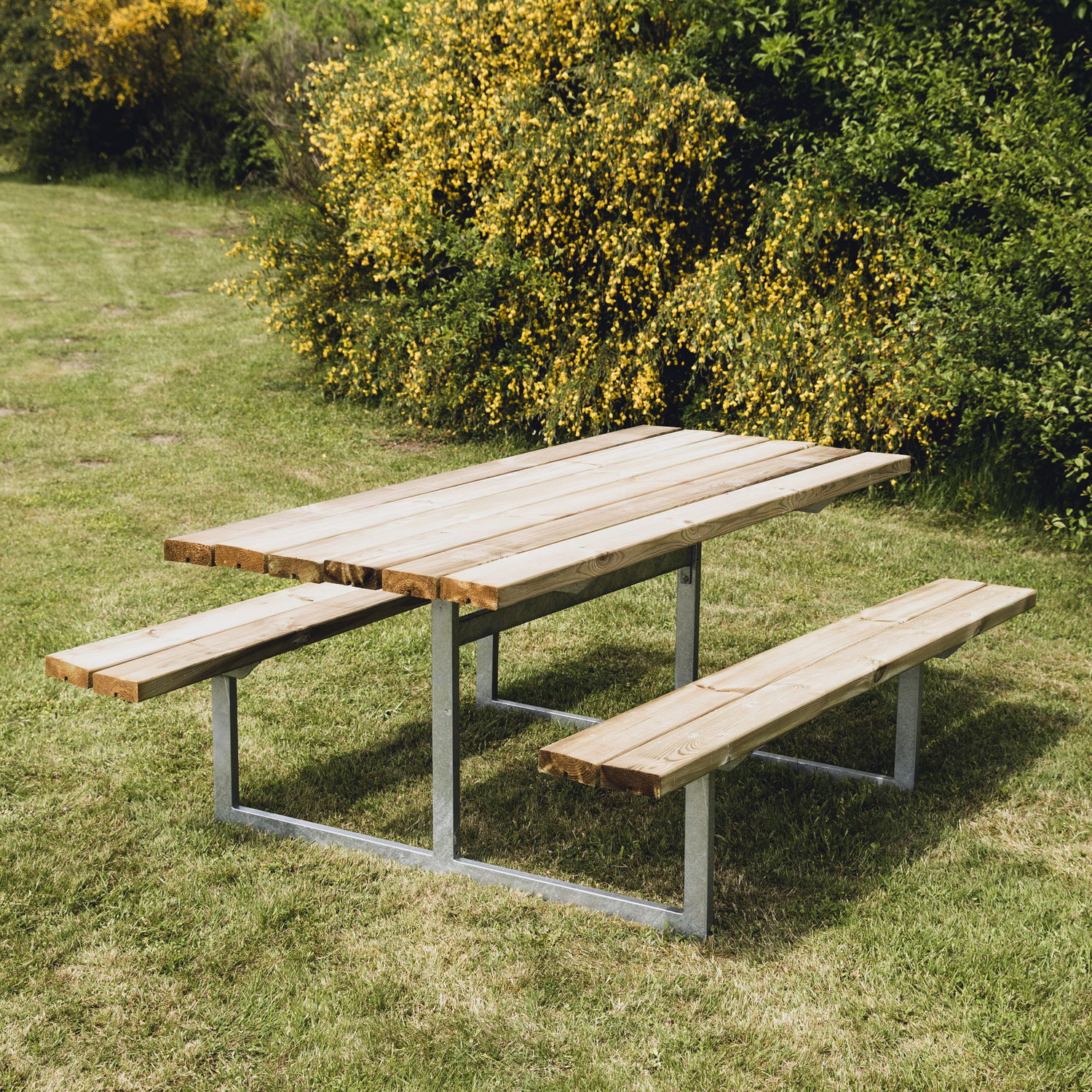 Havebord i træ med integrerede bænke på græsplæne