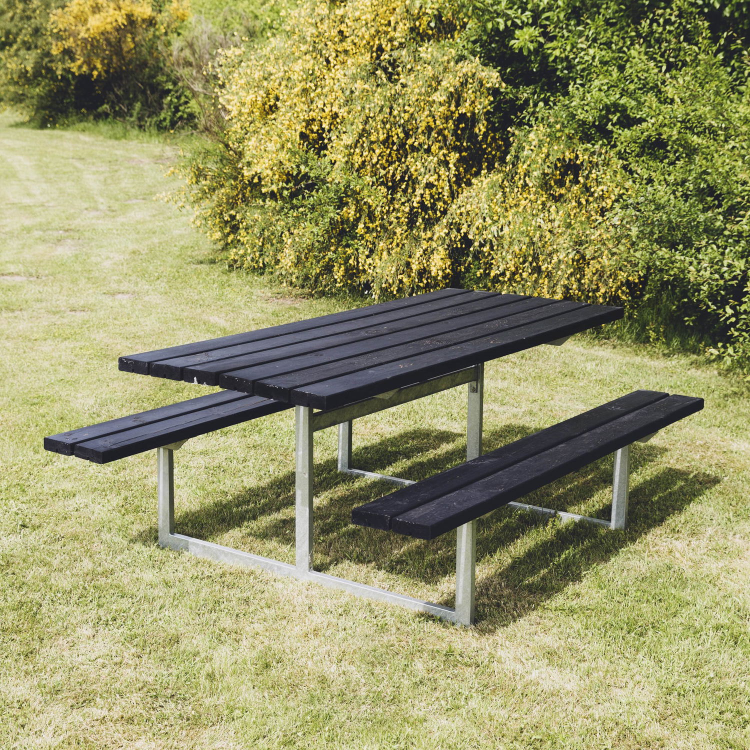 Sort træ-picnicbord med bænke i have