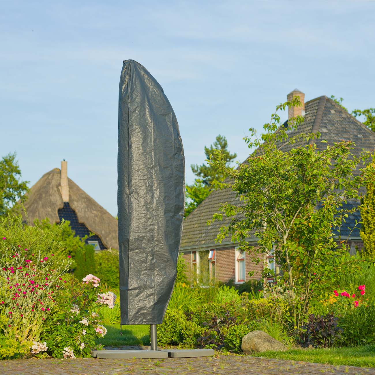 Gråt overtræk beskytter hængeparasol i grøn have