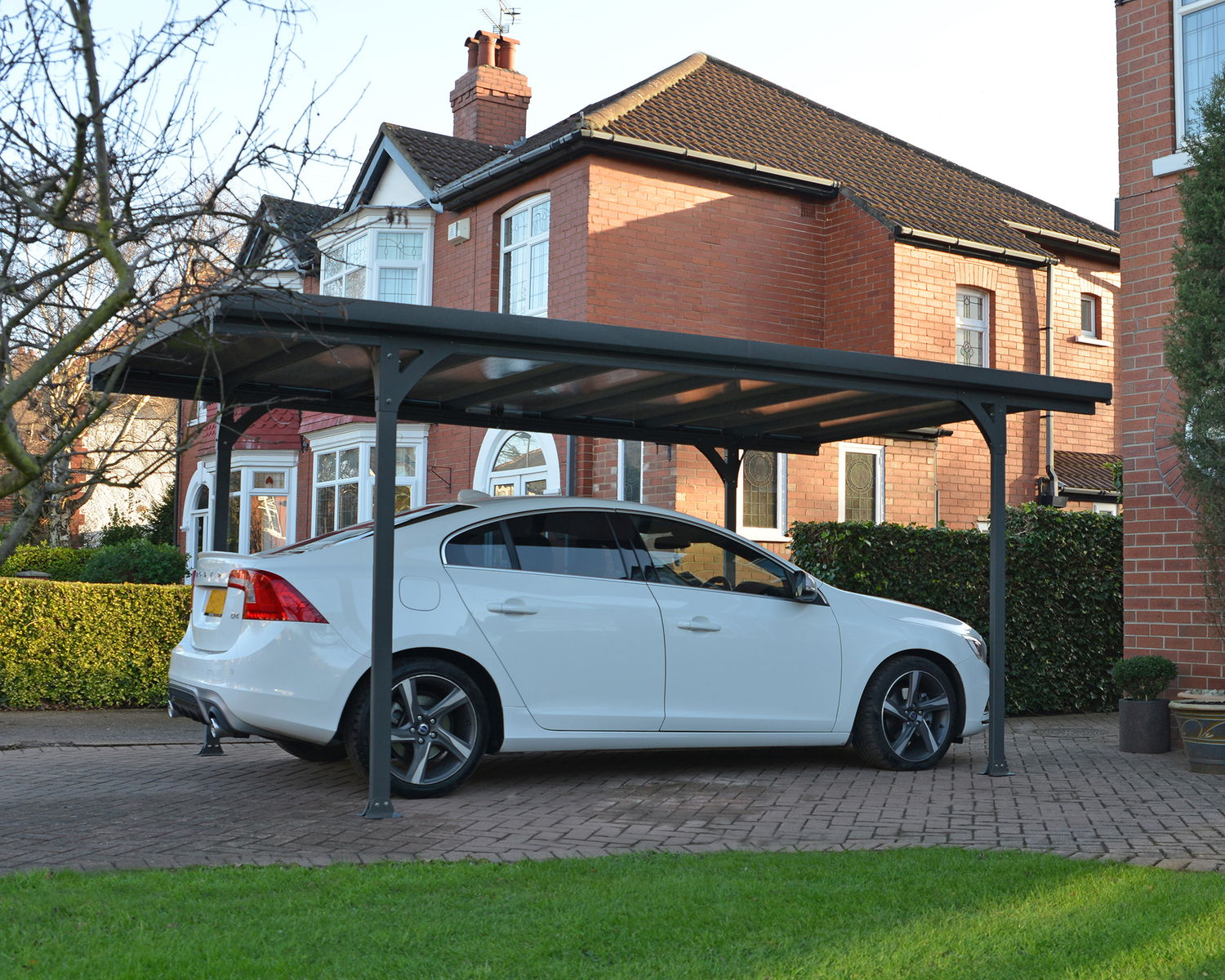 Hvid bil parkeret under moderne metalcarport