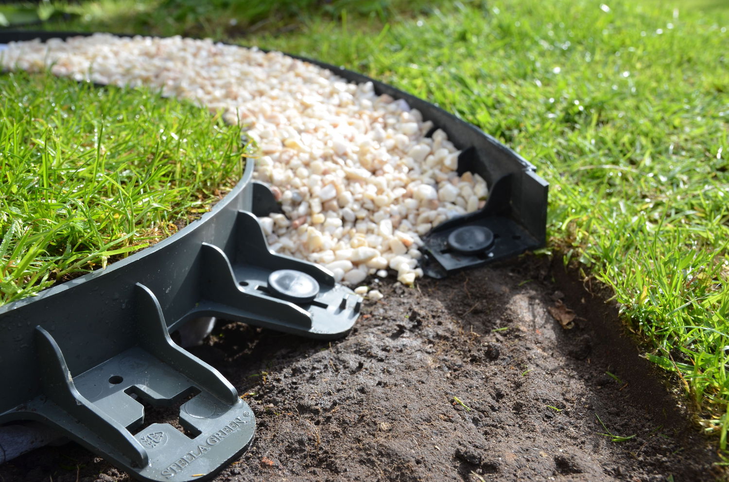 Plast kantsten mellem græsplæne og stenbelægning