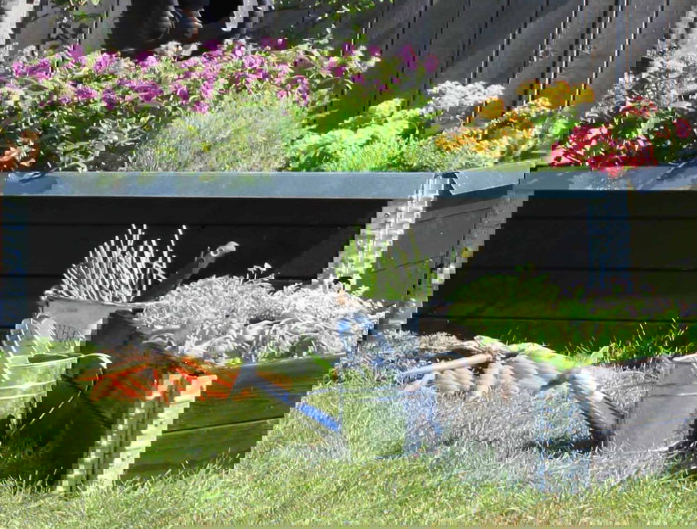 Stort højbed i træ fyldt med farverige blomster