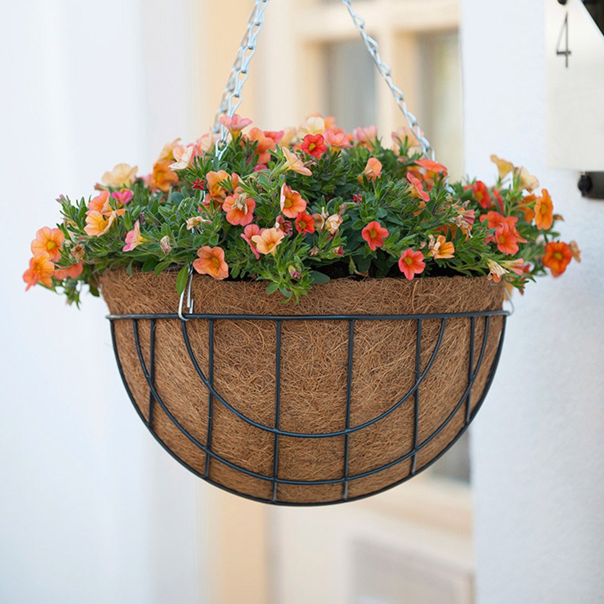 Hængende blomsterkurv i metal med orange små blomster