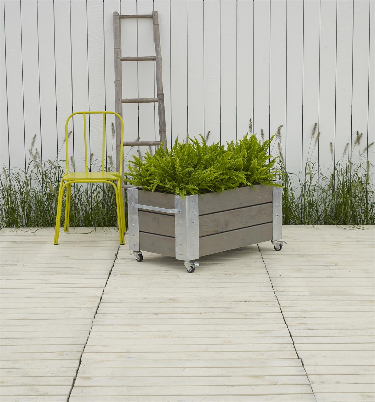 Træplantekasse på hjul til terrasse Rektangulær træplantekasse på hjul med grønne planter