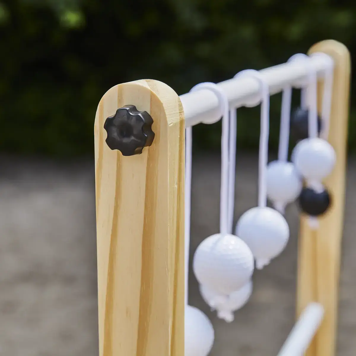 Stigegolfspil i træ med hvide og sorte kugler