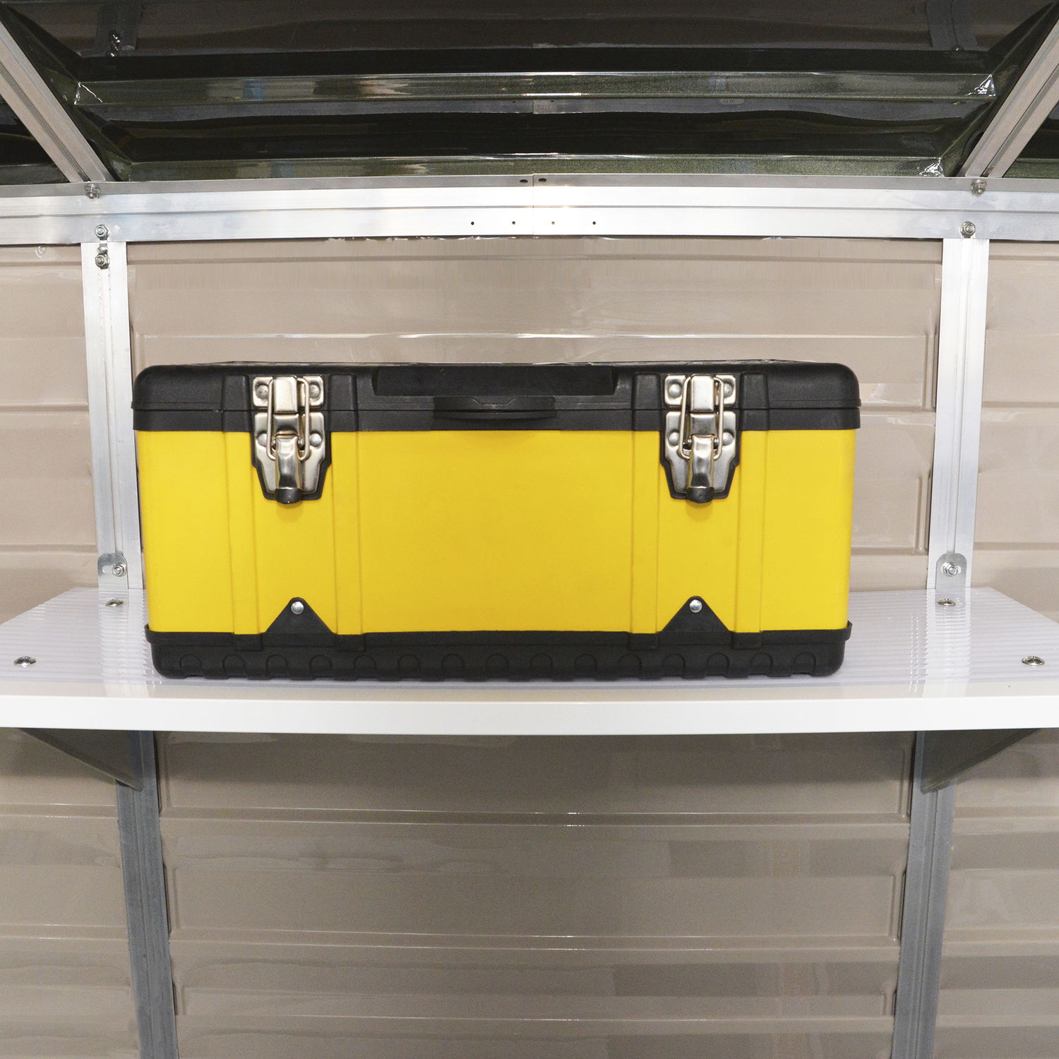 Robust gul værktøjskasse med metalspænder på hylde