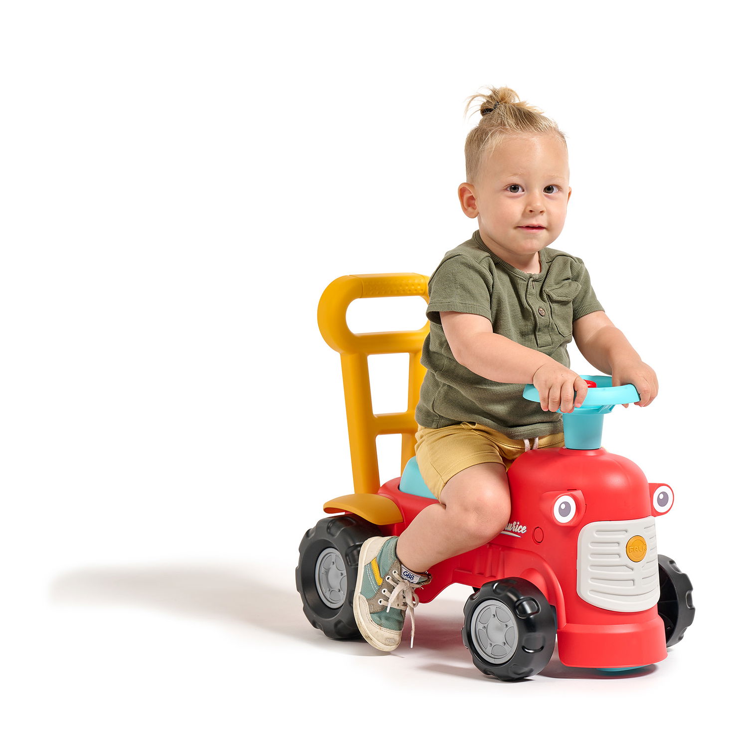 Lille barn leger på rød gåtraktor med fire hjul